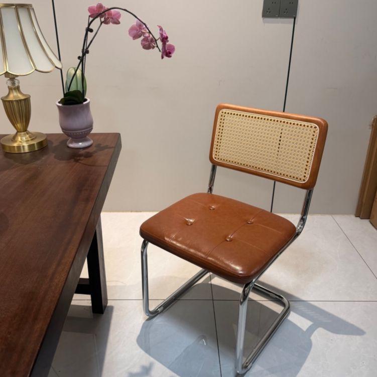 Elegantly crafted armless rattan dining chair in retro pastoral style, perfect for cafes, guesthouses, and vintage settings.