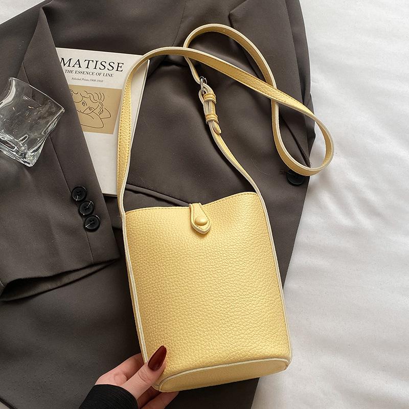 

Korean version of casual macaron color simple lychee pattern mobile phone bag female versatile commuter foreign style messenger bucket bag