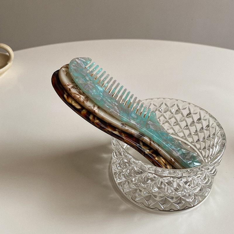 Elegant and compact tortoise shell acetate hair comb for easy portability.