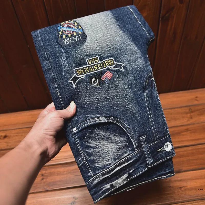 Men's Slim-Fit Embroidered Floral Distressed Jeans with Patches and Elastic Trim.