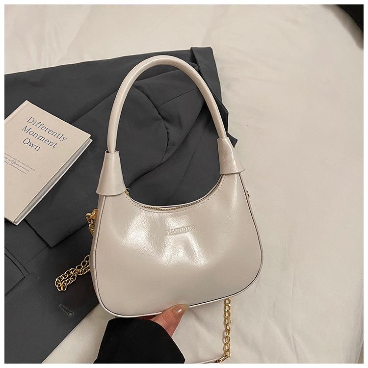 Fashion birth girl small bag 2025 new patent leather design sense portable crescent bag hand carry niche unique underarm bag