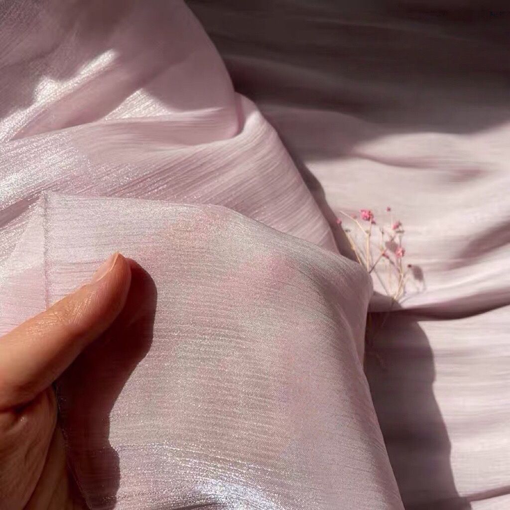 Soft shiny creased organza fabric with a smooth texture suitable for wedding dresses formal gowns and designer clothing fabrics