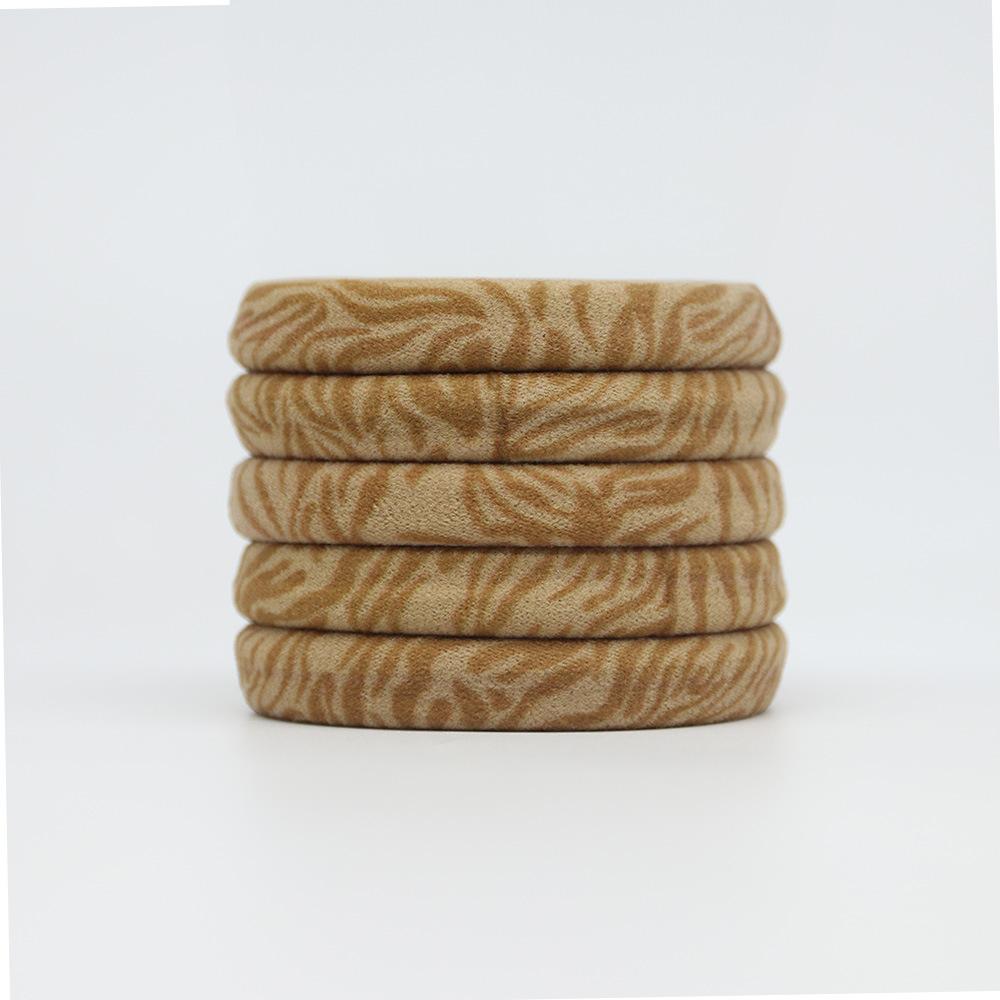 Ein Damen-Haargummi mit einem Handtuch-Haargummi mit Leopardenmuster und einem Zopfgummi schädigt das Haar nicht