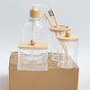 4-Piece Bathroom Set: Transparent Press-Down Soap Bottle, Toothbrush Holder, Bamboo Lid Cotton Swab Box, and Acrylic Cotton Ball Jar