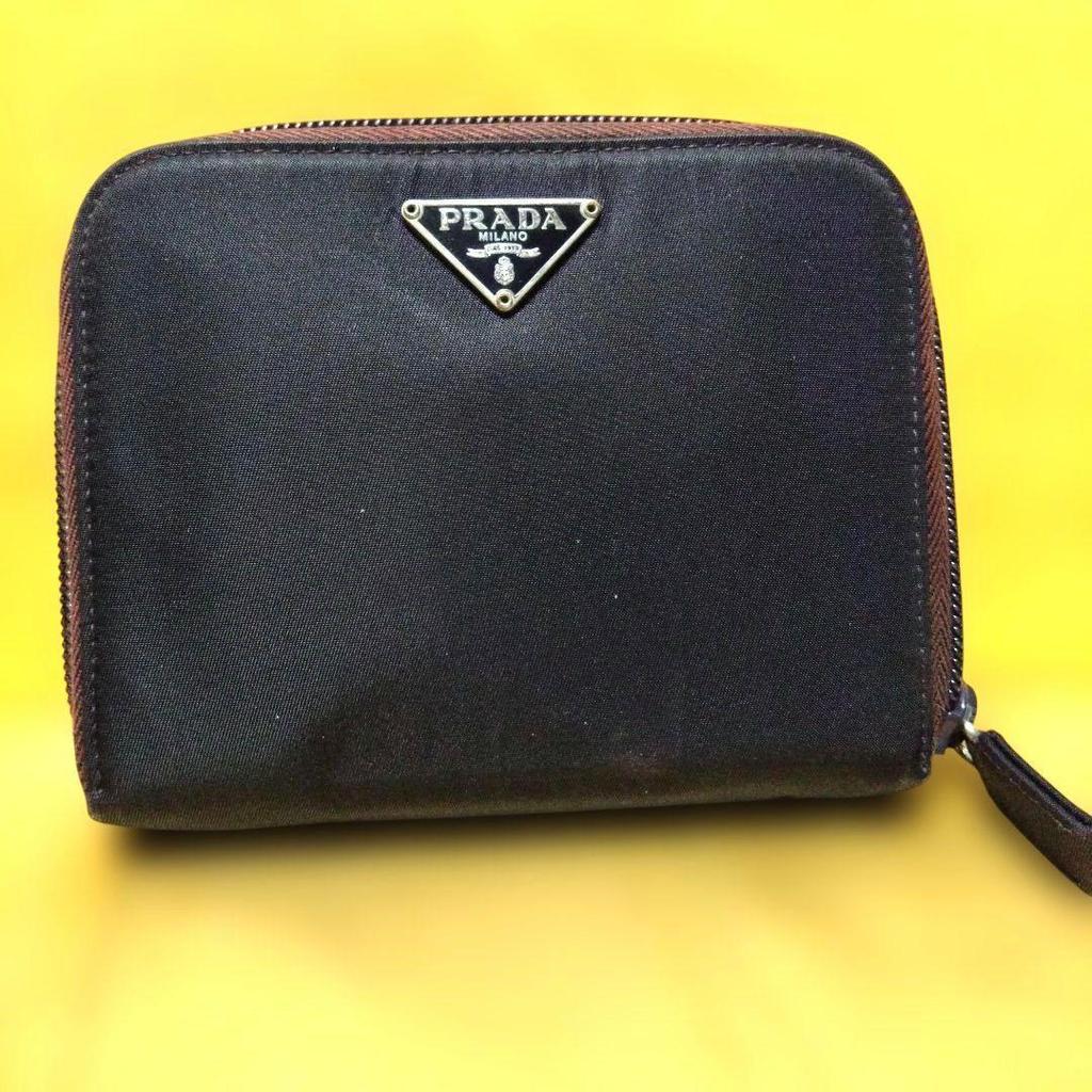 Used Excellent condition PRADA dry plum color bi-fold wallet with triangle logo plate and zipper