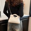 Avslappnad textur nischdesign liten fyrkantig väska 2025 vår ny modetrend dam axelremsväska
