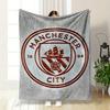 A Circular Emblem with a Ship, Stripes, a Rose, and Text Reading "Manchester City". for All Seasons Blanket Lunch Break Throw Gift