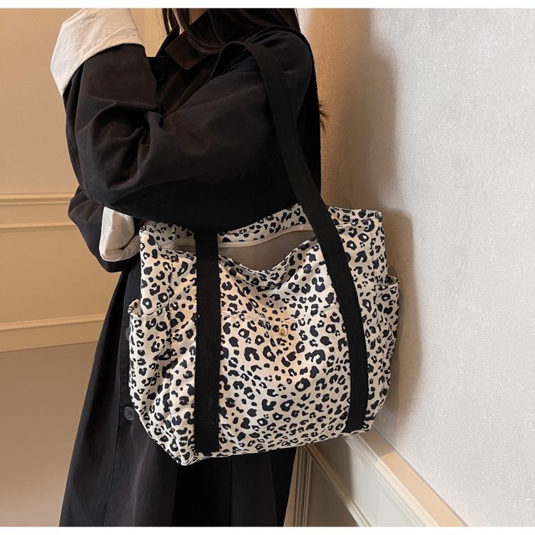 Leopard Print Canvas Tote: Large Capacity Autumn Shoulder Bag for Women, Versatile for College and Commute.