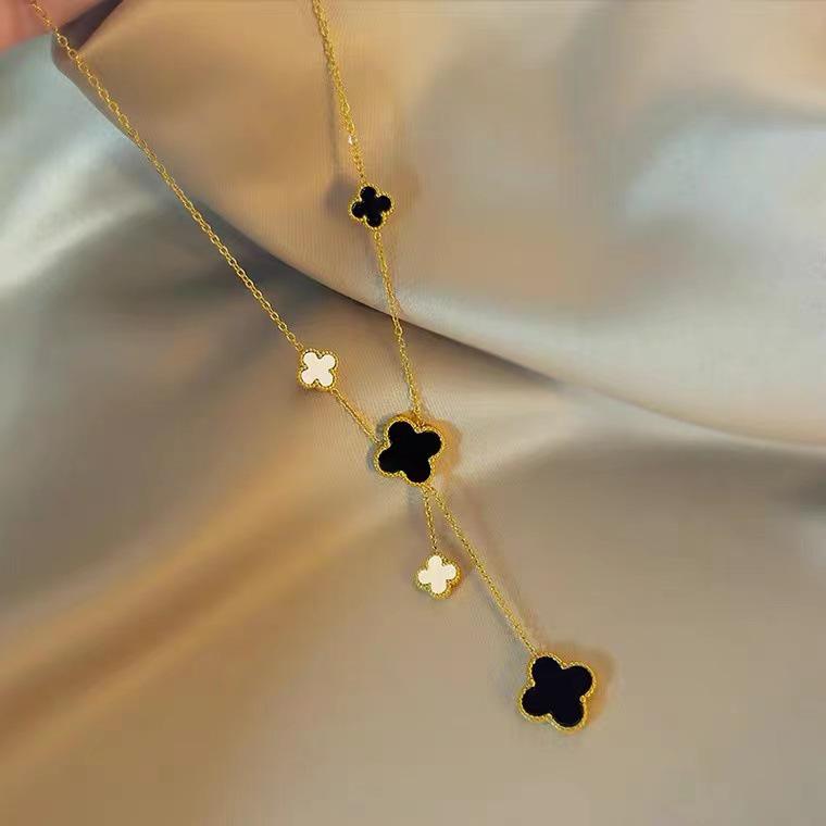 European & American Trendy Hollow Four-Leaf Clover Necklace with Black Shell Tassel Pendant.