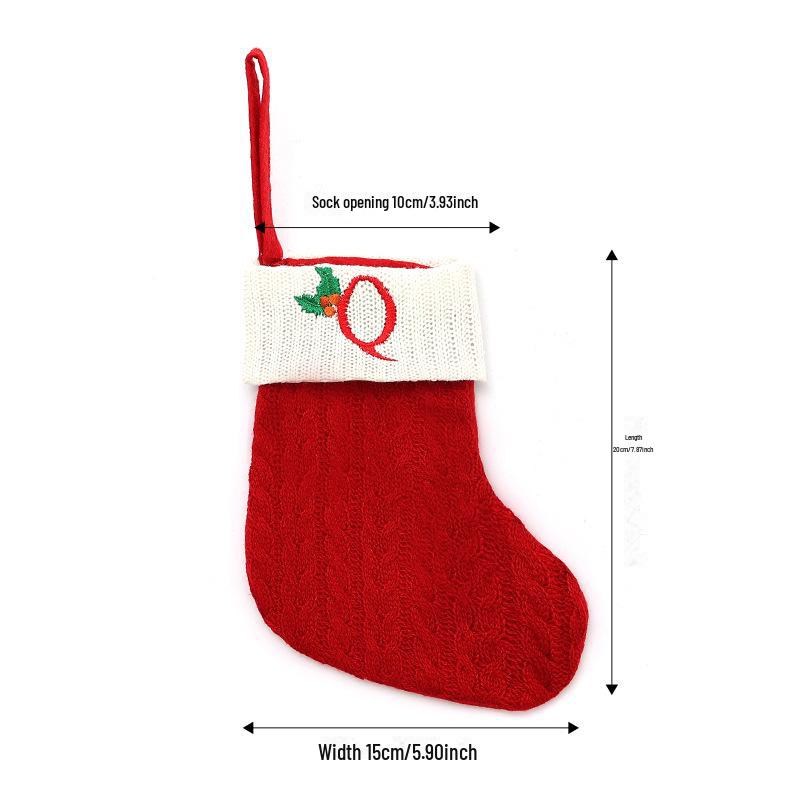 Weihnachtsdekorationen: Rote gestrickte Kinderstrümpfe mit gestickten Buchstaben