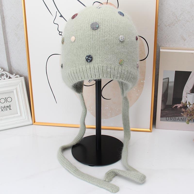 Autumn and winter Angola rabbit fur ear protection knitted hat women's color button decorative lace-up wool hat outdoor cold hat tide