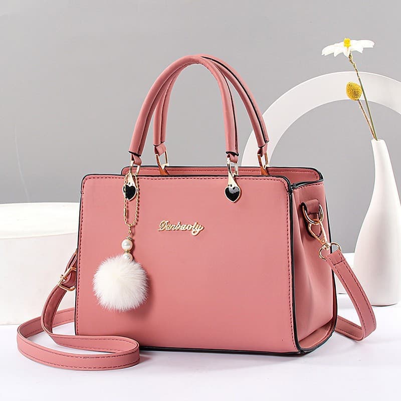Bolsa pequena transversal decorada com bola de pelo, elegante