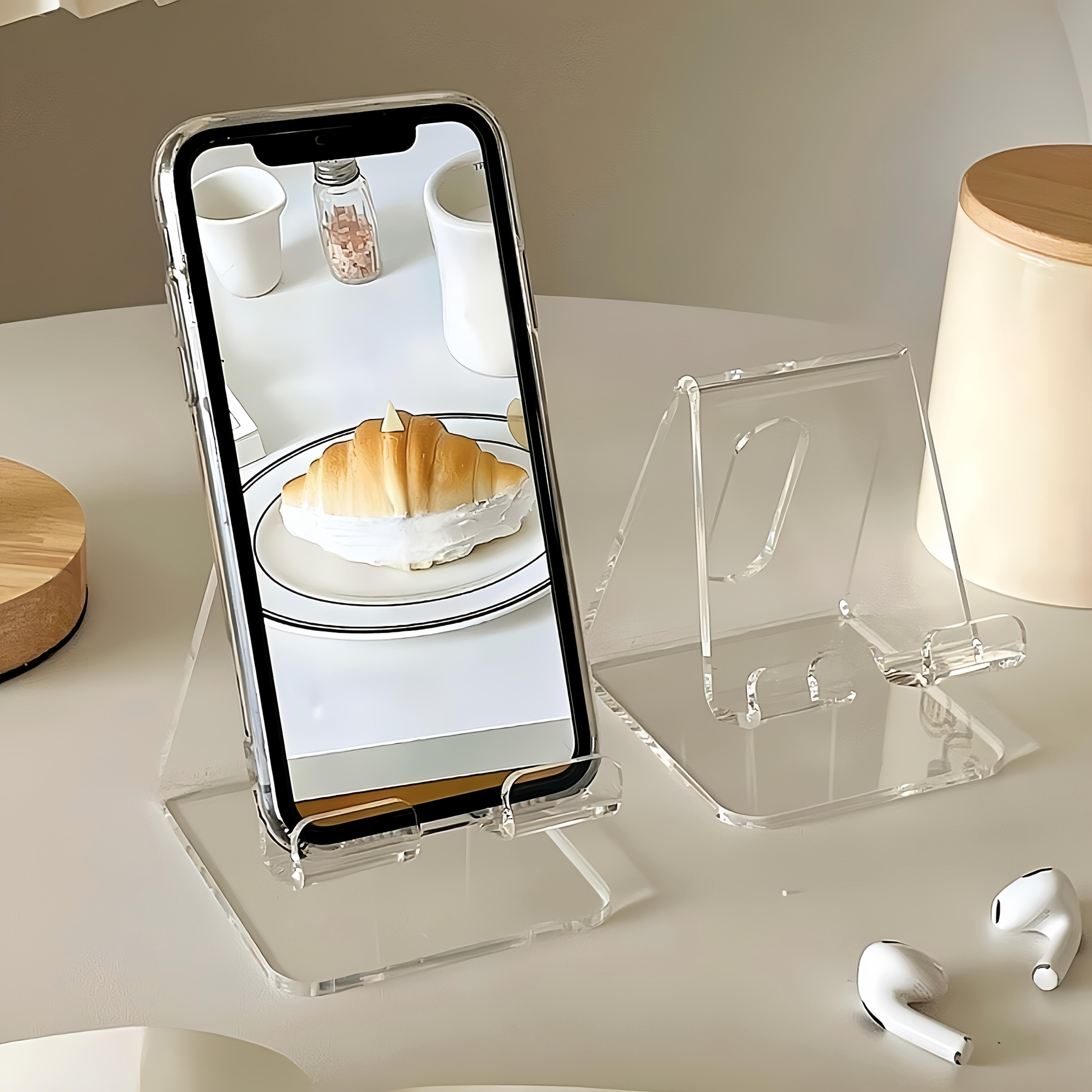 

Adjustable desk phone stand with non-slip base, supports charging, fits phones, tablets and books, space-saving for office use. прозорий