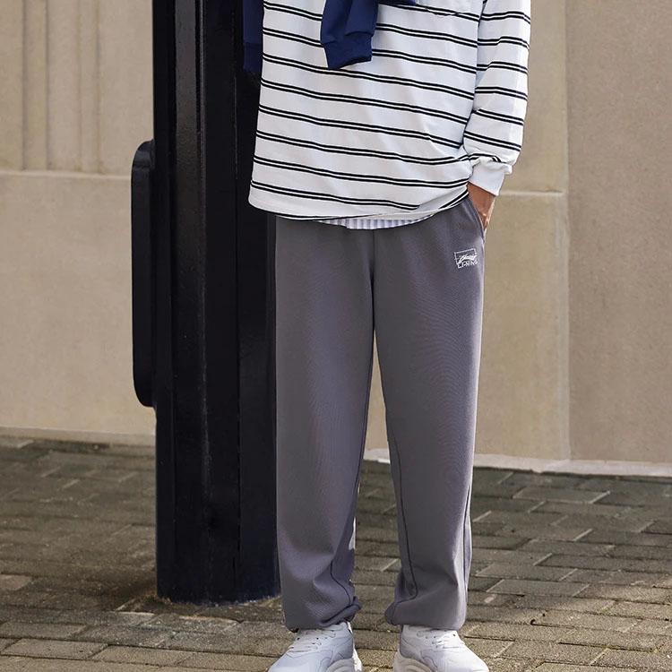 Li Ning Seria Lifestyle Sportowy Nadruk Logo Elastyczne Średnio Wysokie Zwężane Wygodne Oddychające Dzianinowe Spodnie Sportowe Spodnie Męskie Szaroróżowe AKLTB23-4