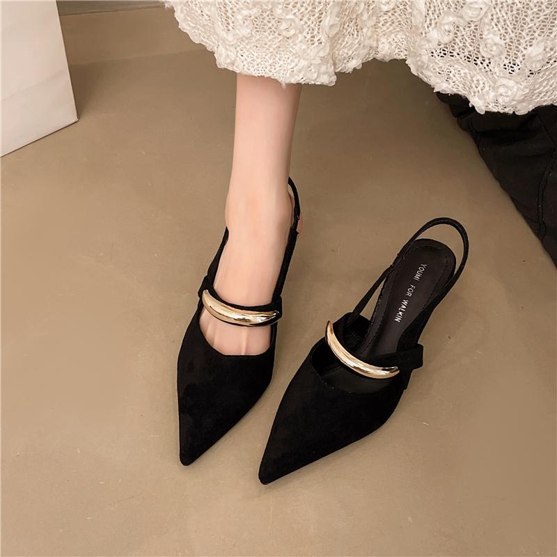 A Woman Wearing Half-slippers with An Inwardly Raised Metal Buckle Toe Cap and A Genuine Leather Pointed Toe on The Outside