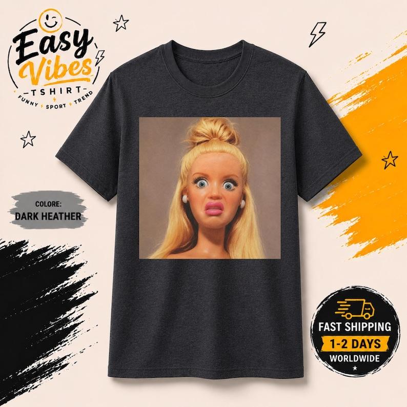 Funny Blonde Doll Face T-Shirt | Creepy Cute Meme Tee | Viral Meme Top | Y2K Aesthetic Women s Top | Sarcastic T-shirt with disgusted doll 2XL