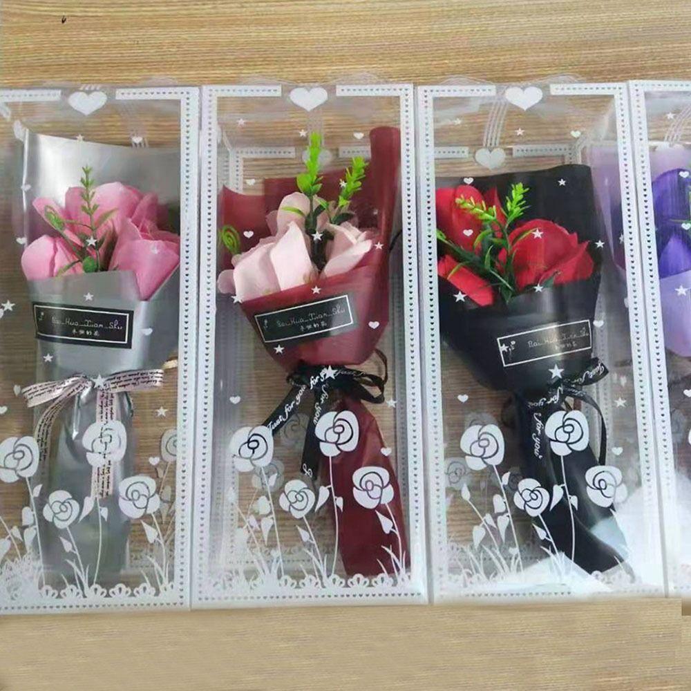 Rokā tur 3 mākslīgo rožu galvas ar kastīti mākslīgo ziedu modes rožu pušķis