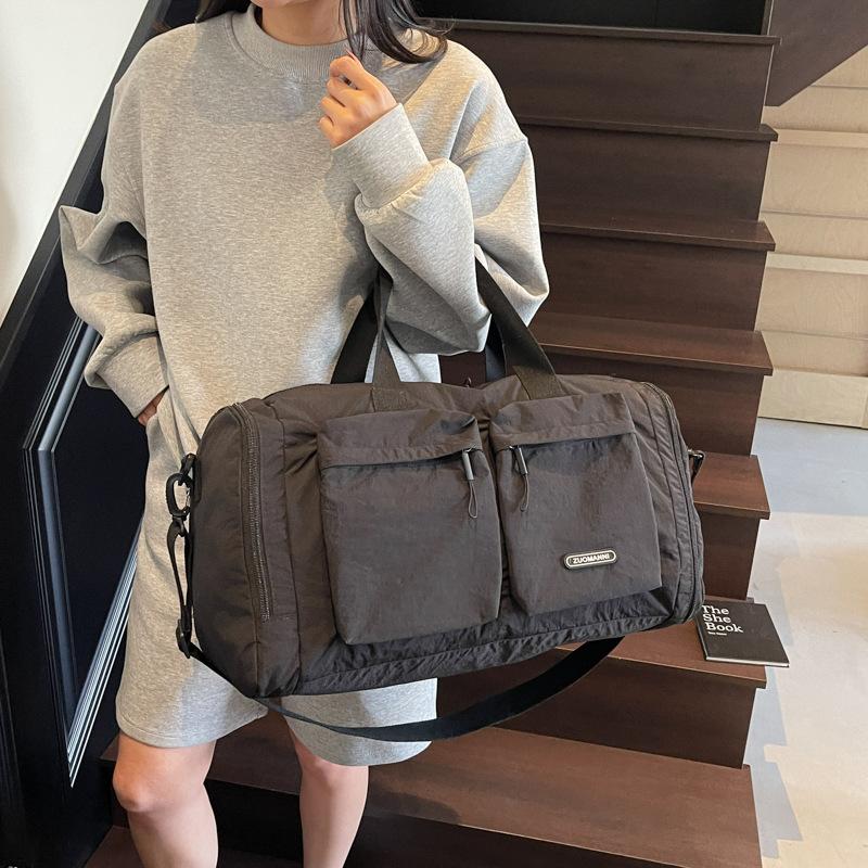 Trocken- und Nassfach Kurzreisetasche Damenhand legt eine Duffeltasche mit großem Fassungsvermögen und mehreren Fächern zur Aufbewahrung für schwangere Frauen zur Entbindung aus