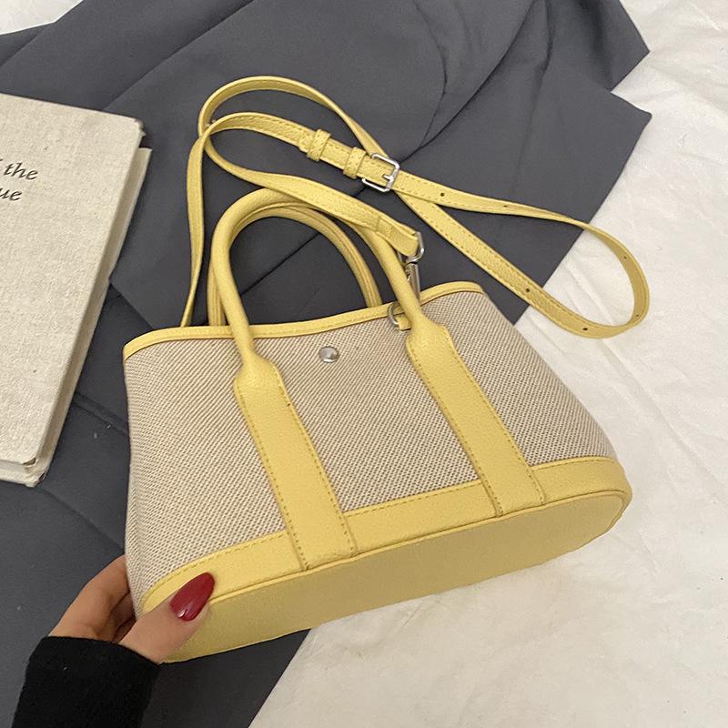 Spring new fashion contrasting color splicing portable bucket bag women's leisure work commuter wind messenger letter bag