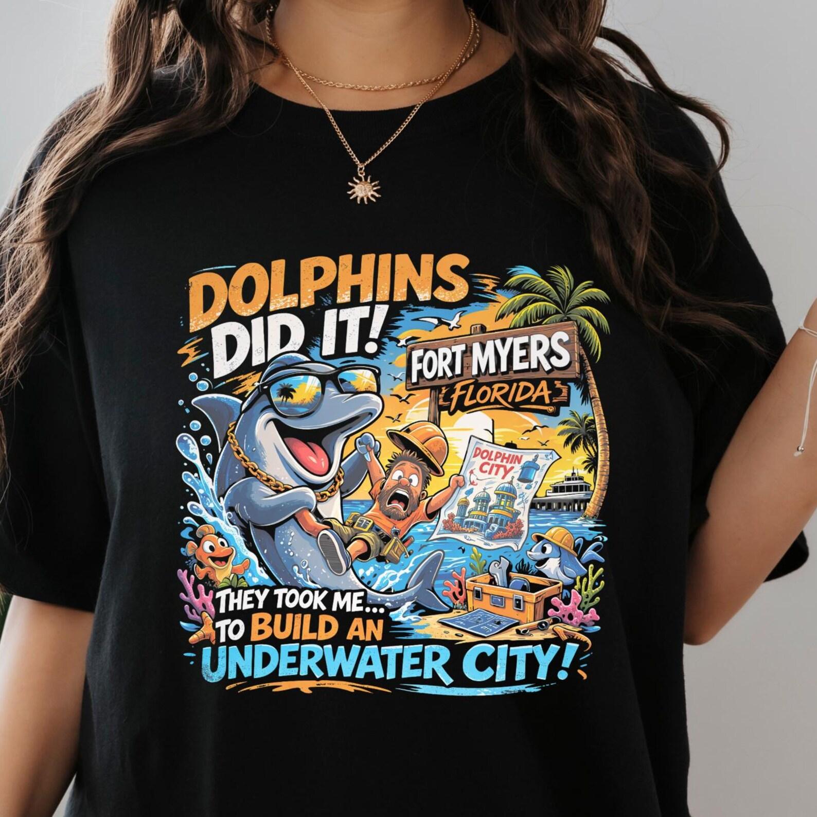 ironic Funny Dolphin Abduction Shirt, Fort Myers Florida T-Shirt, Cartoon Dolphin Meme Tee, Underwater City Humor Shirt, Vacation Beach. 4XL
