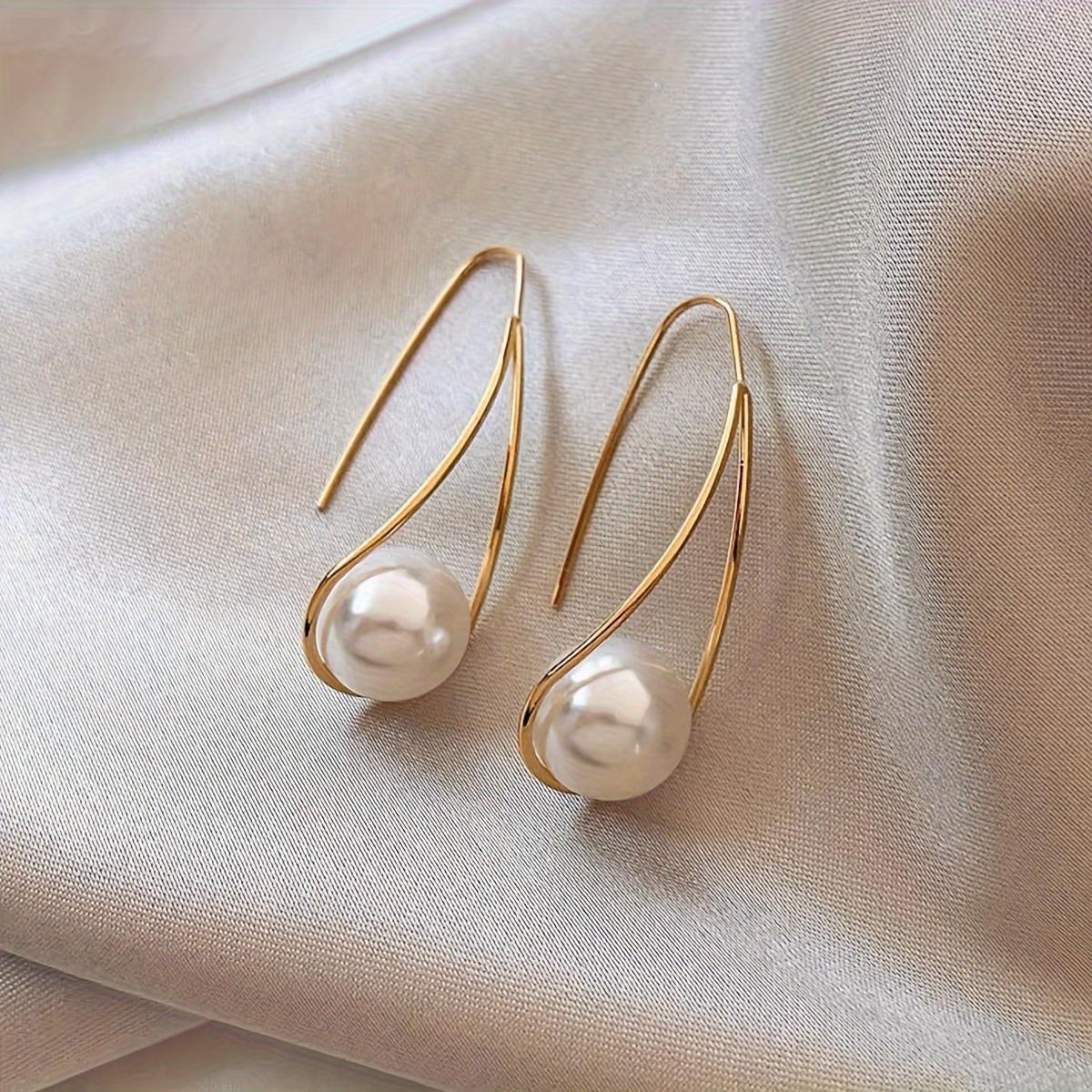 

A pair of geometric, minimalist, stylish, everyday women s faux pearl earrings, an elegant and understated luxury gift for holidays.