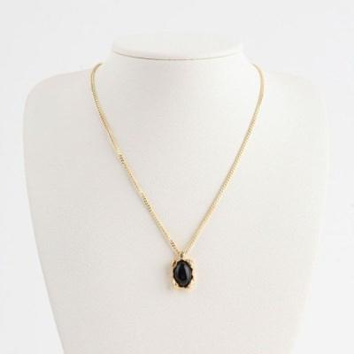 Damesketting met opvallende gouden ketting en zwarte parelhanger