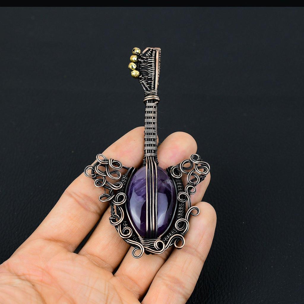 Gitarrenförmiger Amethyst-Edelstein mit Kupferdraht umwickelt, handgefertigter Schmuckanhänger als Geschenk