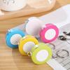A Stylish Keychain Measuring Tape In Vibrant Colors, Featuring A 1.5-Meter Retractable Design, Perfect for Measuring Clothing Sizes