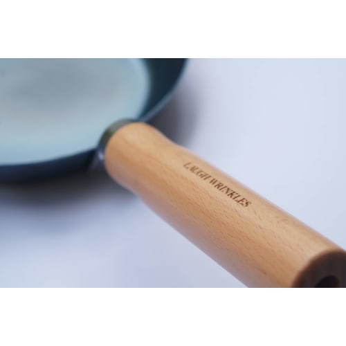 This 24cm iron skillet with a plain wood handle is made in Japan and is suitable for induction cooktops. It's lightweight and requires no seasoning. P