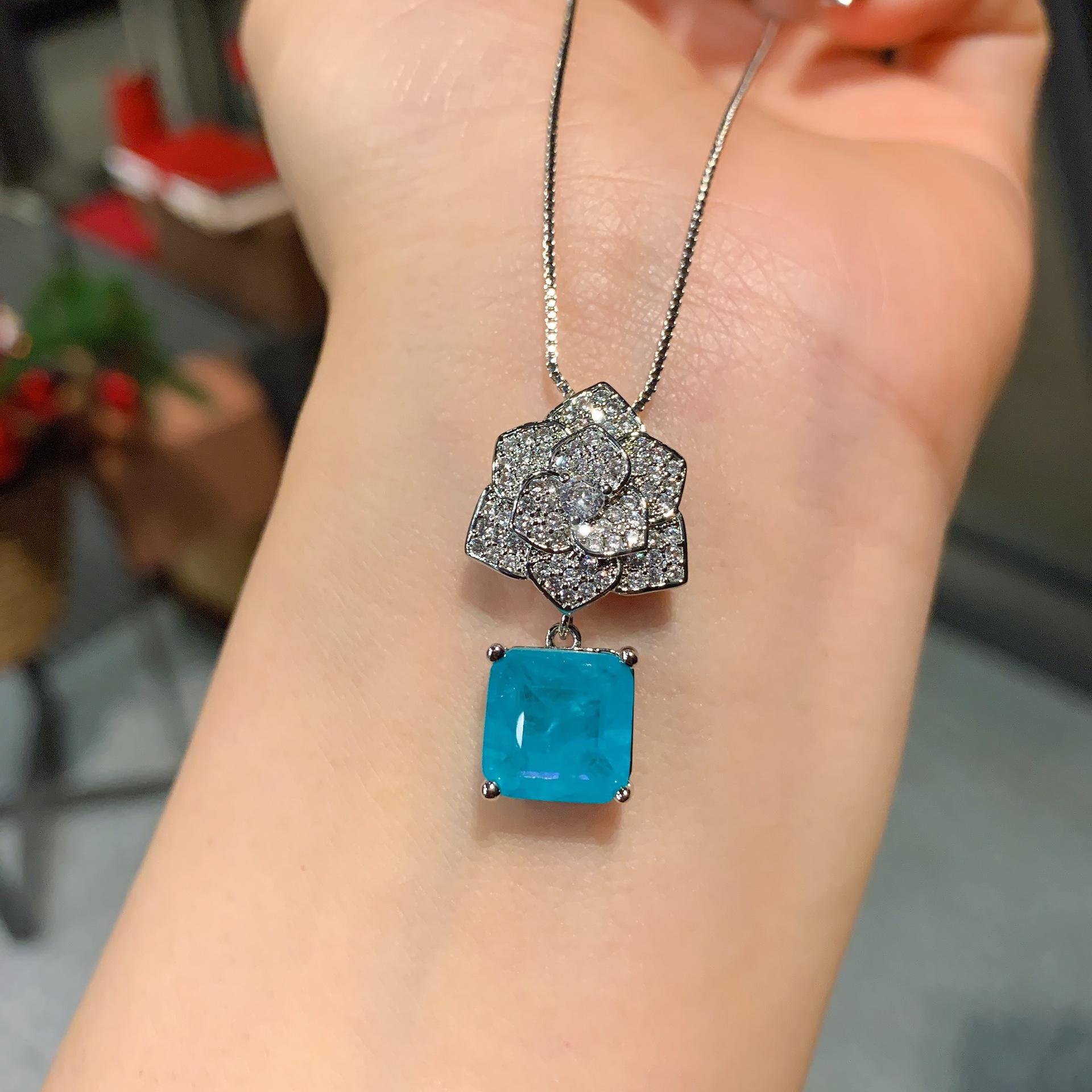 

Ювелирные изделия Имитация Параиба Кольцо Ожерелье Пусеты Набор Форма цветка Креативный Полный бриллиант 10 * 10