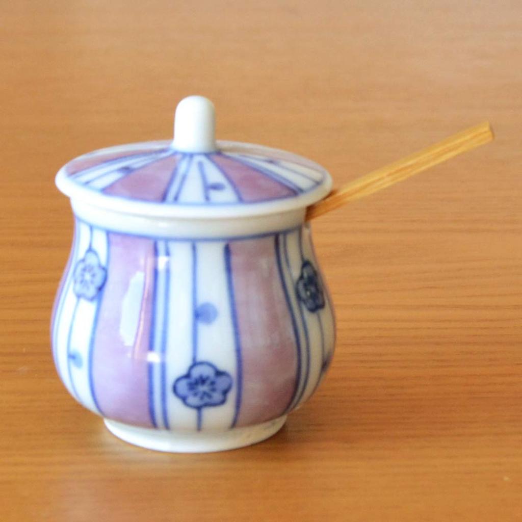 Stylish ceramic condiment container with lid and bamboo perfect for home or commercial Made in Japan by Arita featuring a chestnut plum spoon, use.