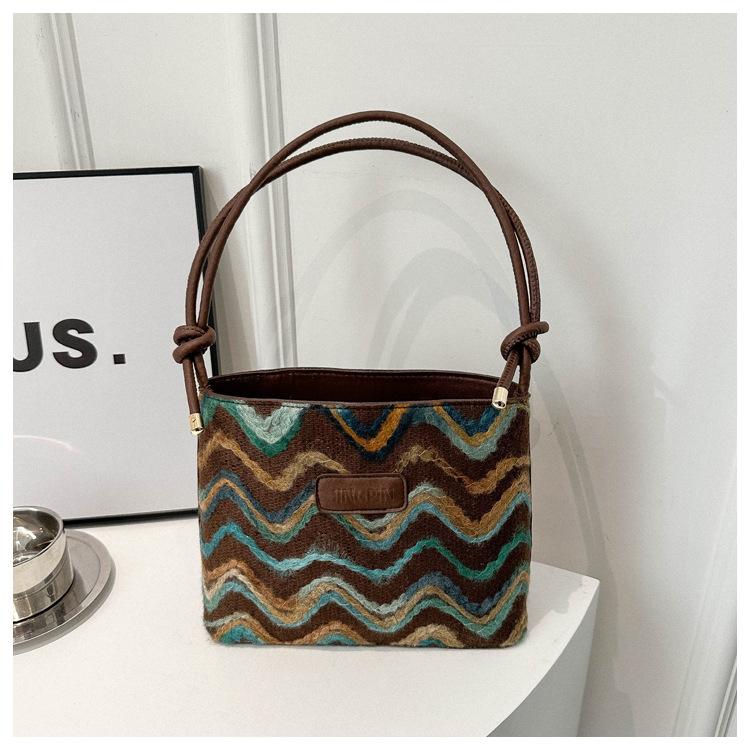 

Модные полосы, весенний тренд, контрастные цвета, плетение, фактура, индивидуальность, одно плечо, диагональная сумка-ведро под мышкой темно-коричневого