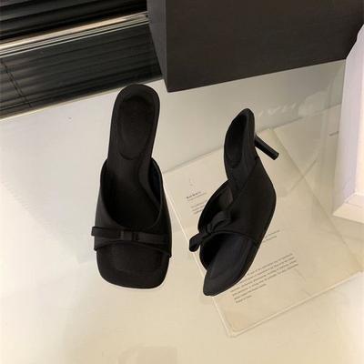 Hausschuhe Frauen tragen im Frühjahr und Sommer 2025 eine schwarze Schleife aus Satin mit offenem Zehenbereich und Stiletto-High-Heels