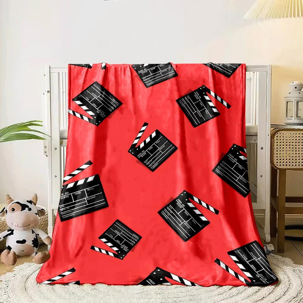 Diagonal pattern of black clapperboards on a vibrant red background. for all seasons blanket lunch break throw gift 80cm x 120cm