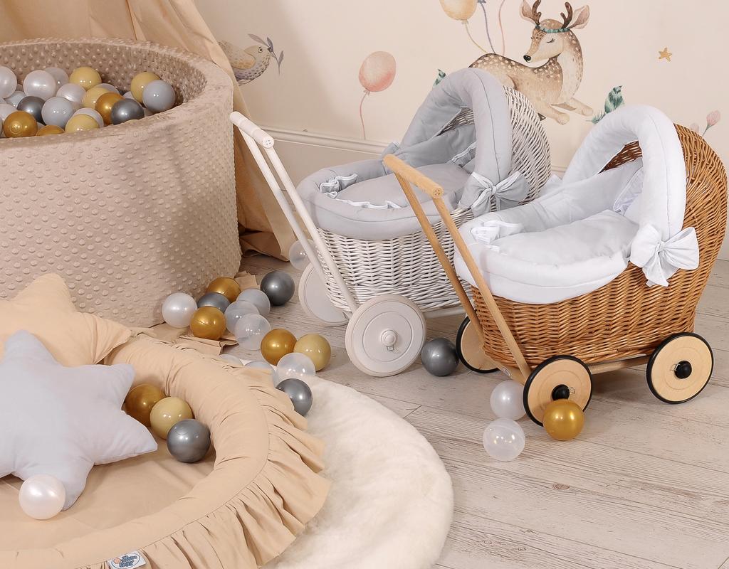 Witte rieten poppenwagen met grijze beddengoed en zachte voering