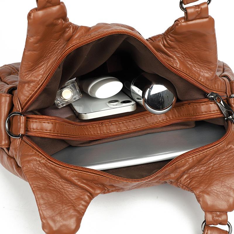 Shoulder leather locomotive bag New large-capacity women's bag Atmospheric commuter bag Woven leather button pleated bag