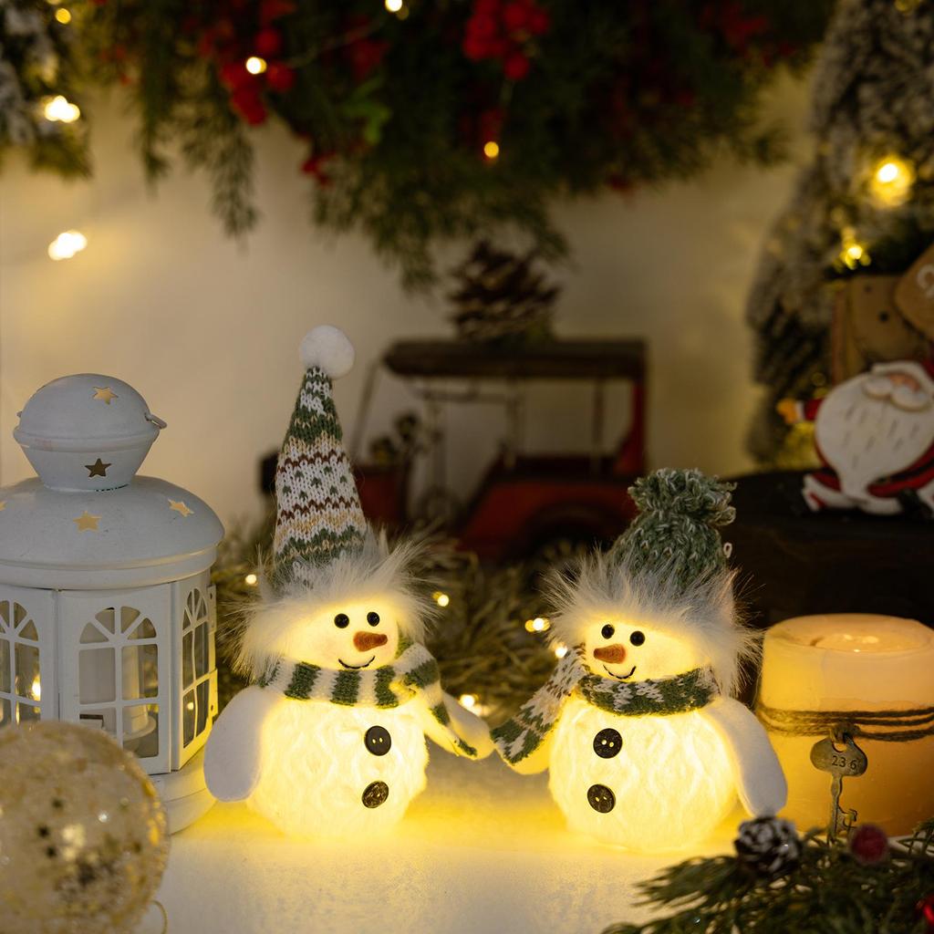 Weihnachts-Schneemann-Dekoration mit grüner Strickmütze und Lichtern