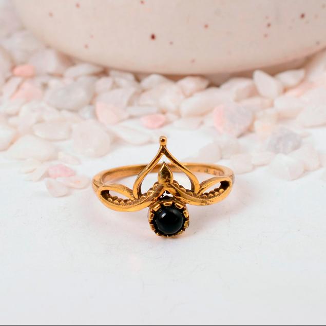 Ornate Black Onyx Crown Ring: Gold-toned jewelry with a round black cabochon and a delicate lotus or tiara-style setting.