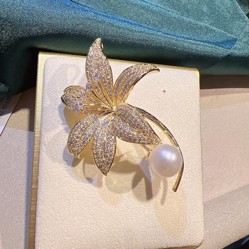 

Изысканная женская брошь «Лилия»: Позолоченная медь, микро-инкрустация цирконом, брошь-корсет с жемчугом