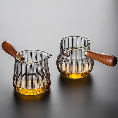 Jarra de vidrio resistente al calor con mango de madera, ideal para cocina, café y leche.