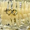 Grillz dentale a forma di cuore traforato placcato oro 18 carati, gioiello personalizzato per denti.
