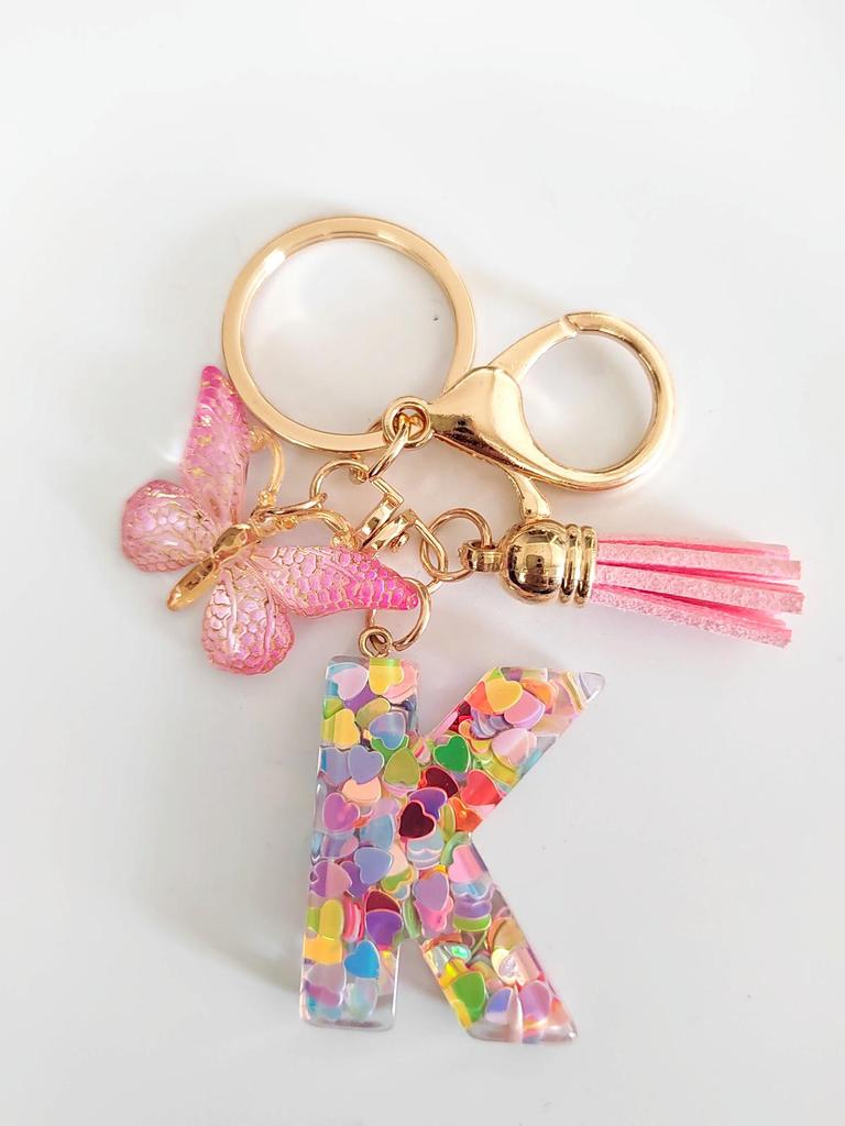 Rosa Glitzer Epoxidharz Schlüsselanhänger mit englischem Buchstaben und Schmetterlingsquaste