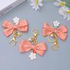 Niedlicher Sakura Fliege Schlüsselanhänger Mode Perlenkette Handtaschenanhänger Autoschlüsselanhänger Kopfhörerhülle DIY Ornament für Frauen Souvenir Schmuck