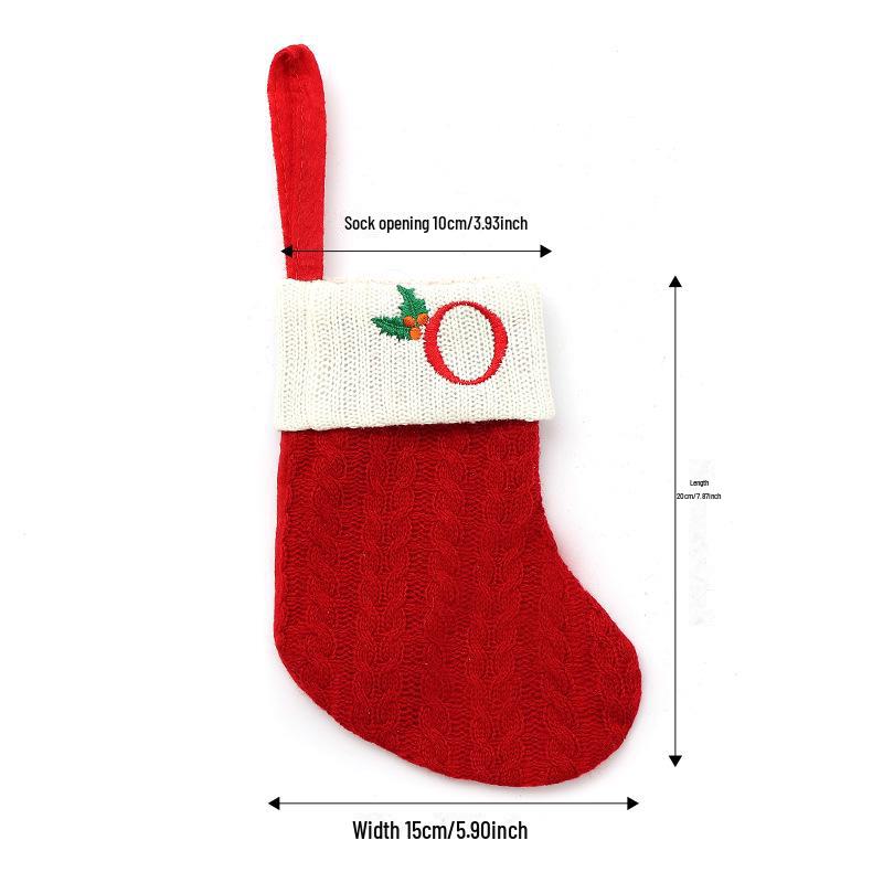 Weihnachtsdekorationen: Rote gestrickte Kinderstrümpfe mit gestickten Buchstaben