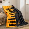 Orange elongated bars and circles merge into a black background diagonally. for all seasons blanket lunch break throw gift