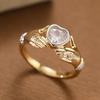 Luxurious hands holding a heart-shaped synthetic gemstone ring made of copper. Women's jewelry ring for a banquet.