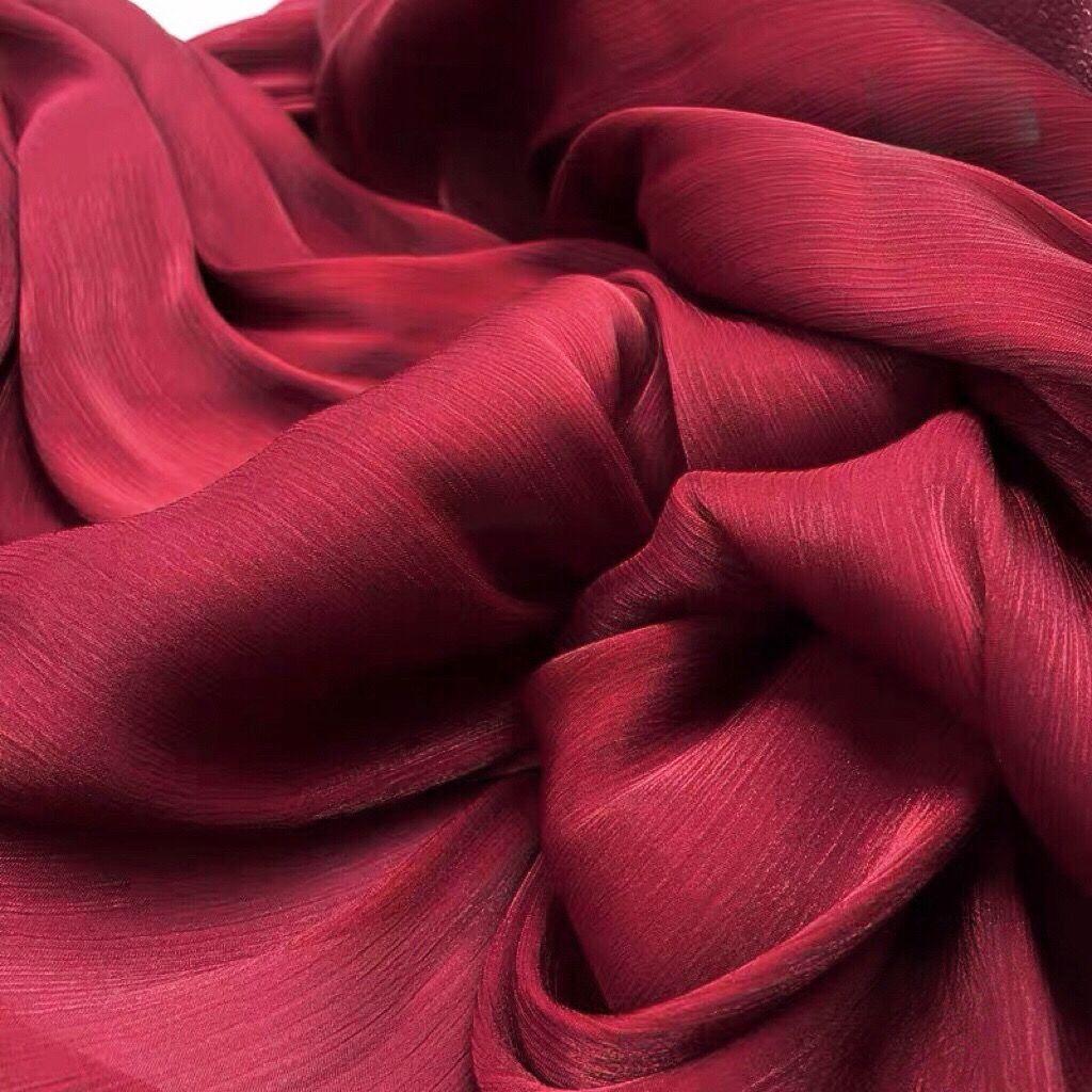 Soft shiny creased organza fabric with a smooth texture suitable for wedding dresses formal gowns and designer clothing fabrics