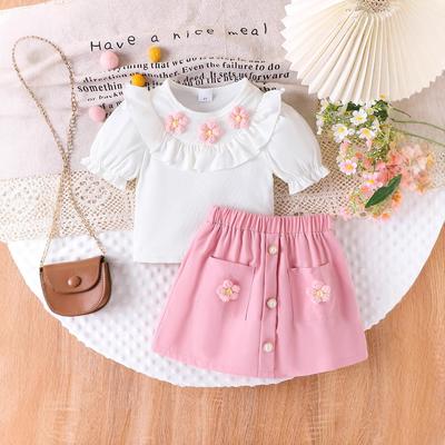Dziewczęcy uroczy zestaw 2025 Letnia dziecięca moda kwiatowa dekoracja krótki rękaw + zestaw spódnic