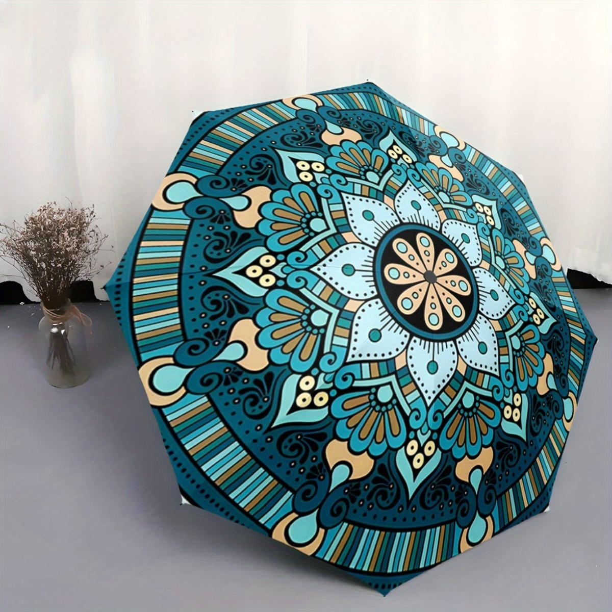 

This Umbrella Has a Detailed Mandala Design in Shades of Blue And Beige. It Is a Compact, Foldable Accessory Perfect for Casua
