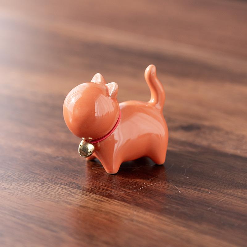 Eine kleine niedliche Katze im chinesischen Stil als Teehaustierfigur mit einem Keramik-Katzenpinselständer